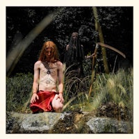 a man sitting on a rock with a scythe in his hand